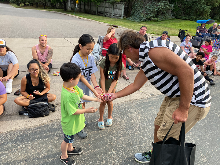 security technician handing candy to kids during parade