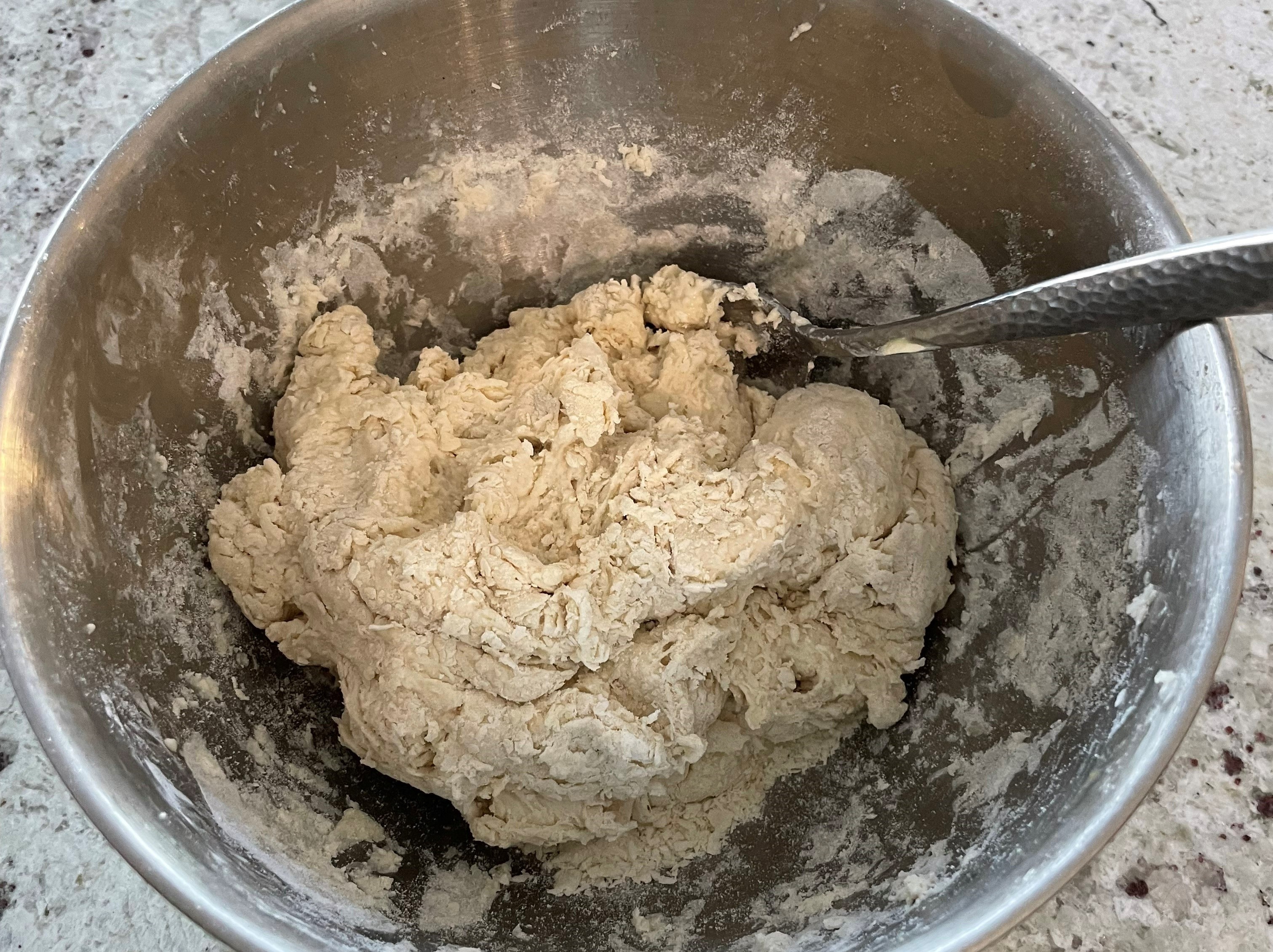 Metal bowl with dumpling dough ball and spoon